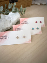 Load image into Gallery viewer, small four point flower or star design studs in white, turquoise blue and hot pink on a table
