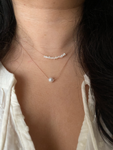 Load image into Gallery viewer, white freshwater pearl bar on a silk cord, shown worn along with a single pearl necklace.