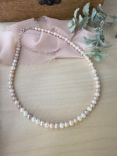 Load image into Gallery viewer, Pink and white round freshwater Pearl necklace on a table. 