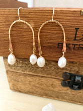Load image into Gallery viewer, white freshwater pearl drops suspended from a gold fill upside down U shaped frame displayed against a brown box 